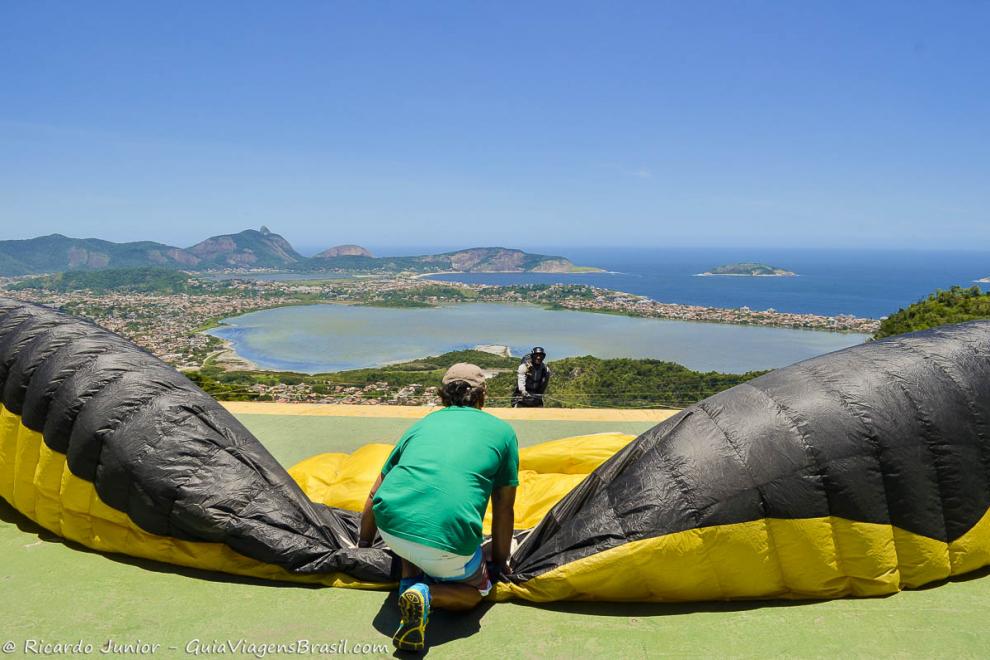 Imagem de duas pessoas preparando paraquedas para salto.